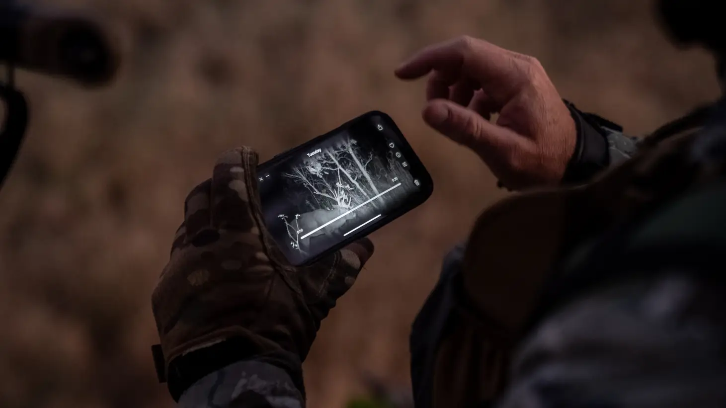 Man holding phone with RECONYX Connect app on screen